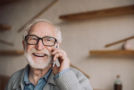 Elderly man on the phone smiling