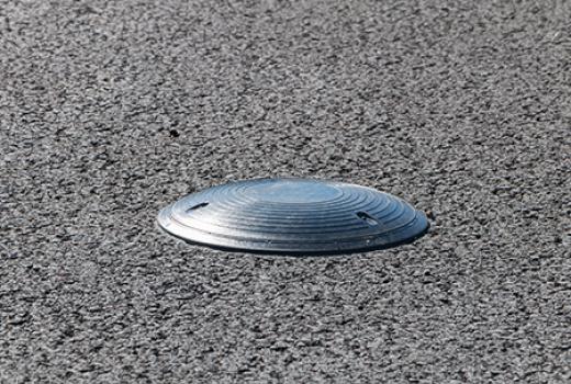 Silver coloured disc embedded in road surface