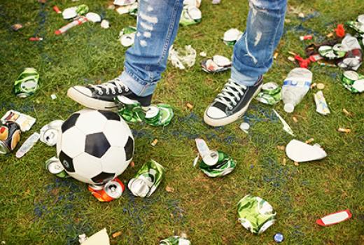 litter on ground around feet with a soccer ball