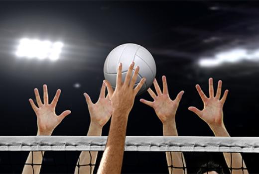 Hands reaching for ball above volleyball net