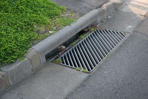 Gutter of a stormwater drainage system in perspective on the side of an road