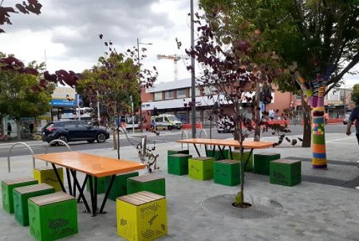 Tables and stools on paved area in town centre