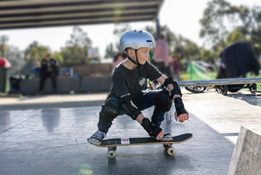 Young boy on crouching on skateboard
